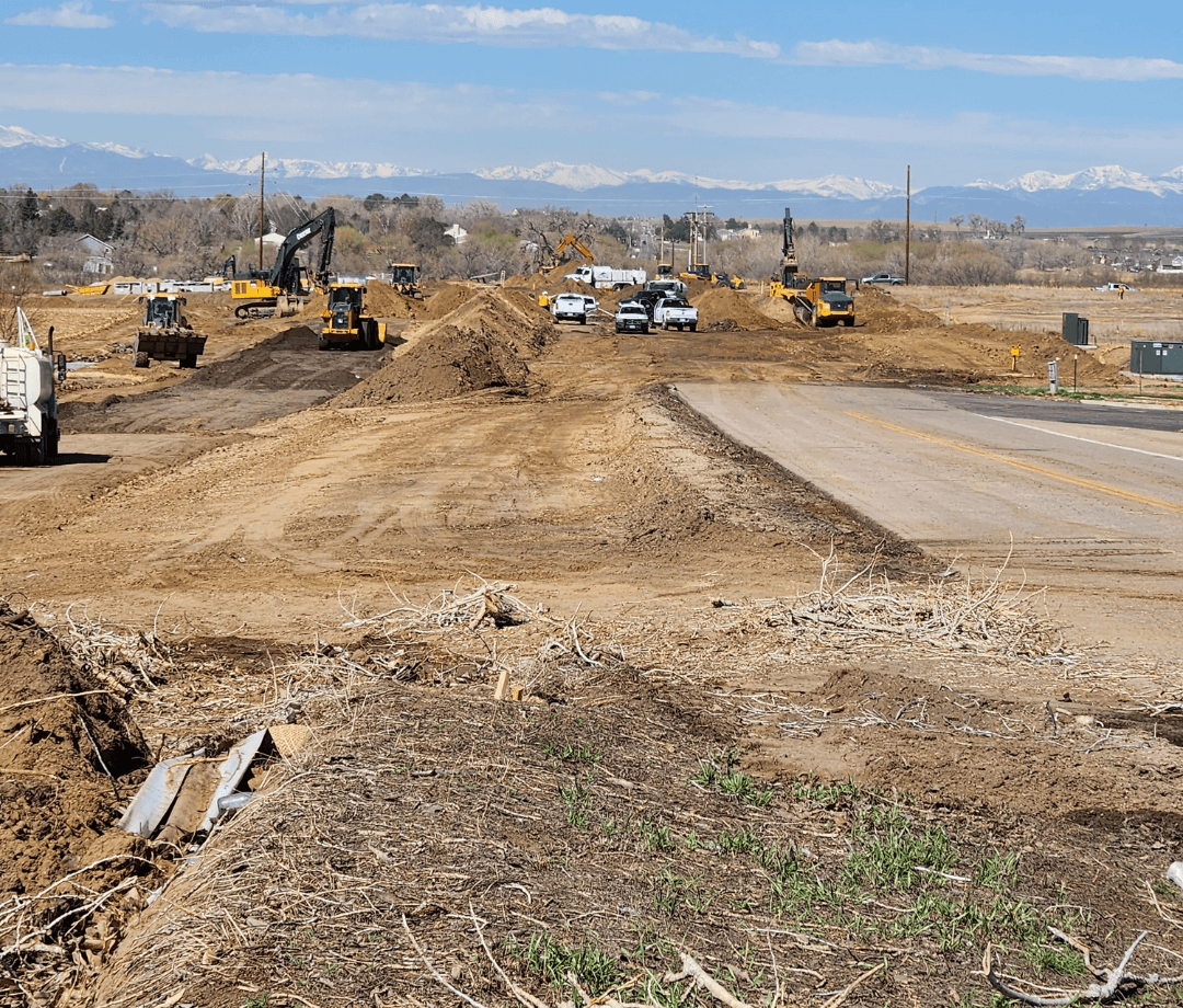 Wide view of active roadway construction with heavy equipment